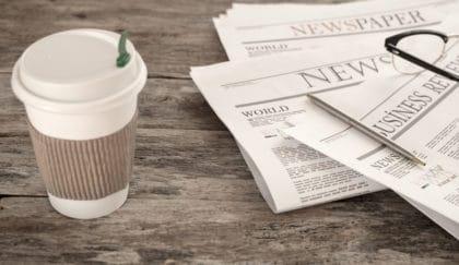 Newspaper and coffee on wooden table