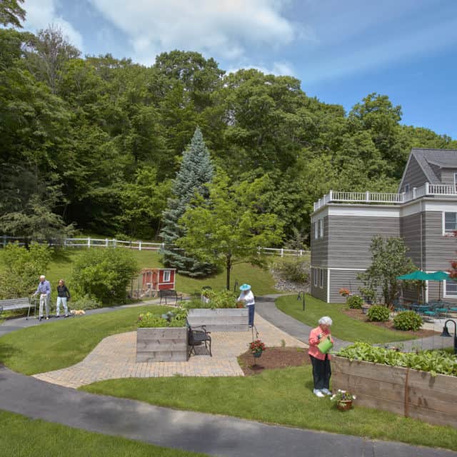 Outdoor courtyard at Goddard House featuring residents gardening
