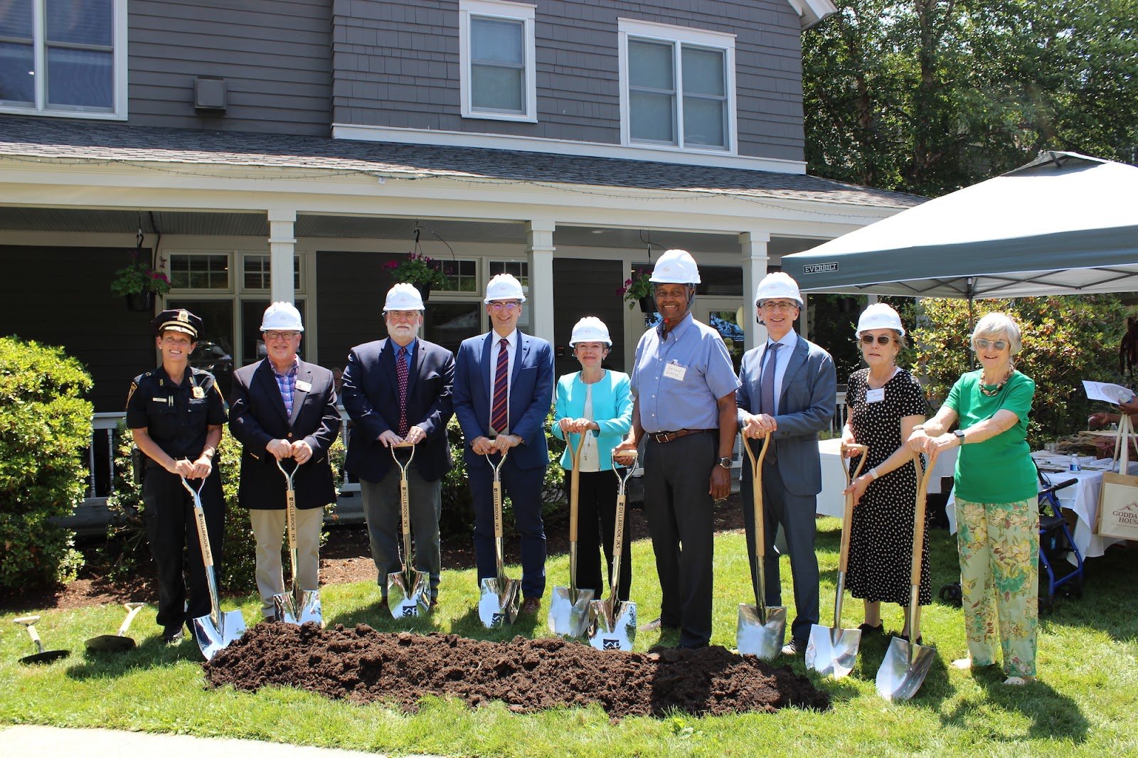 Group of people in construction hats with shovels break ground on renovation project